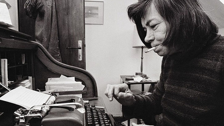 La autora Patricia Highsmith escribiendo en una máquina de escribir mecánica, con un cigarrillo encendido en los labios